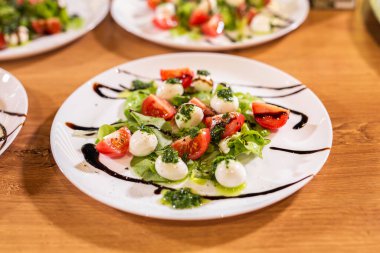 Plate of Healthy Classic Caprese Salad with Mozzarella Cheese, Tomatoes and Basil