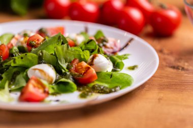 Plate of Healthy Classic Caprese Salad with Mozzarella Cheese, Tomatoes and Basil