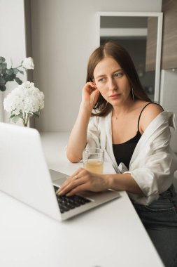 Genç ve güzel bir bayanın internette yazdıktan sonra çay içip bilgisayarda dolaşırken rahat bir odada tek başına oturması. Mesafe öğrenme ve mola ile çalışma