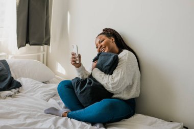 African american woman making video call, in kitchen - social networks