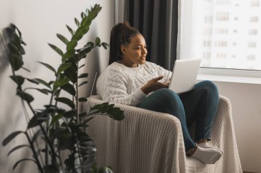 African american woman making video call, in kitchen - social networks