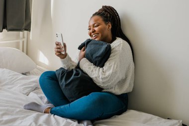 African american woman making video call, in kitchen - social networks