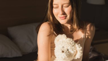 Güzel kadın onun yatağında uyanmak o gülümseyen ve germe