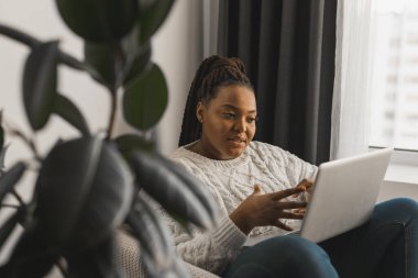 African american woman making video call, in kitchen - social networks