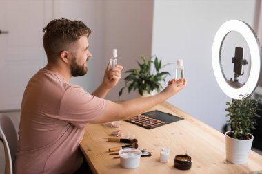 Sakallı adam profesyonel güzellik makyaj sanatçısı vlogger veya blog yazarı web sitesi veya sosyal medya paylaşımı için makyaj dersi kaydediyor