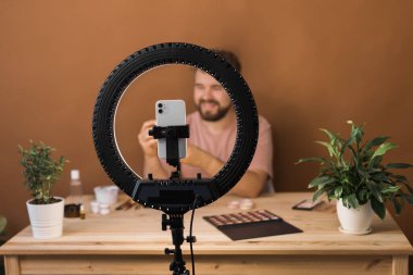 Adam makyaj sanatçısı için kozmetik ve özel ders hakkında vlog kaydedicisi yayını yaptı