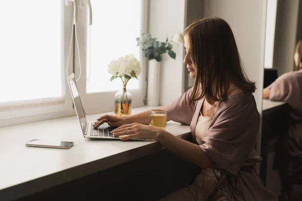 Genç Bir Kadın Oturma Odasında Oturup Çay Içerken Dizüstü Bilgisayarda — Stok fotoğraf