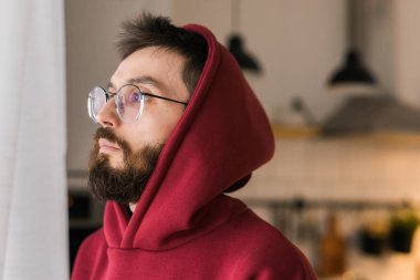 Side view of man longing and looking through window in sad day - depression and melancholy