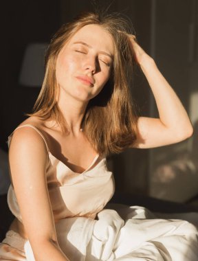 Güzel kadın onun yatağında uyanmak o gülümseyen ve germe