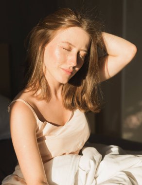 Güzel kadın onun yatağında uyanmak o gülümseyen ve germe