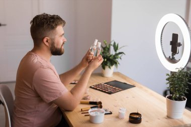 Adam makyaj sanatçısı için kozmetik ve özel ders hakkında vlog kaydedicisi yayını yaptı