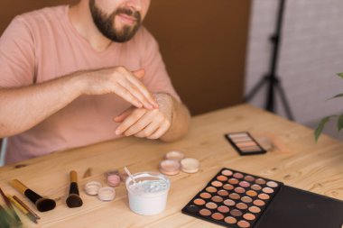 Erkek güzellik blogcusu makyaj yapıyor ve cep telefonuyla bir video dersi kaydediyor - vlog, çeşitlilik ve video blogu