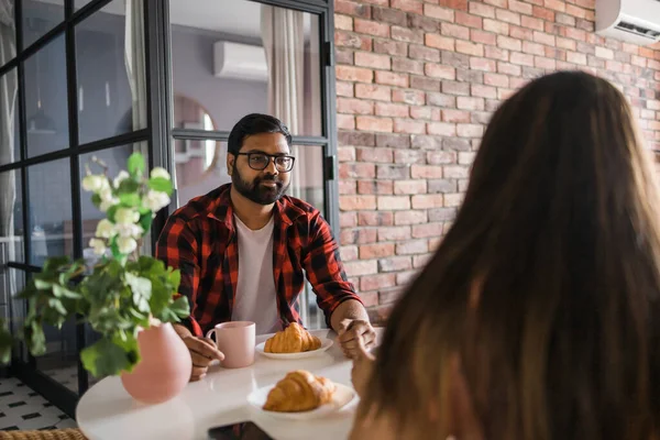 Young Diverse Loving Couple Eating Croissant Talks Together Home Breakfast — Stockfoto