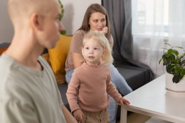 Deaf child girl with cochlear implant studying to hear sounds - recovery after cochlear Implant surgery and rehabilitation