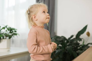 Deaf child girl with cochlear implant studying to hear sounds - recovery after cochlear Implant surgery and rehabilitation