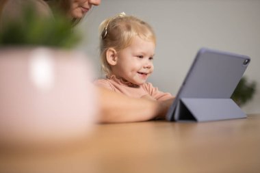 Deaf child girl with cochlear implant studying to hear sounds - recovery after cochlear Implant surgery and rehabilitation