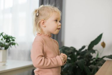 Deaf child girl with cochlear implant studying to hear sounds - recovery after cochlear Implant surgery and rehabilitation