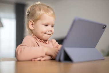 Deaf child girl with cochlear implant studying to hear sounds - recovery after cochlear Implant surgery and rehabilitation