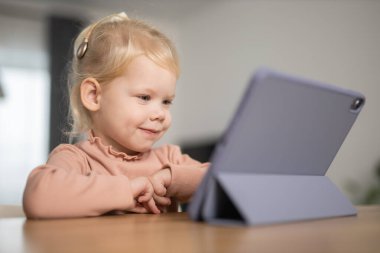 Deaf child girl with cochlear implant studying to hear sounds - recovery after cochlear Implant surgery and rehabilitation