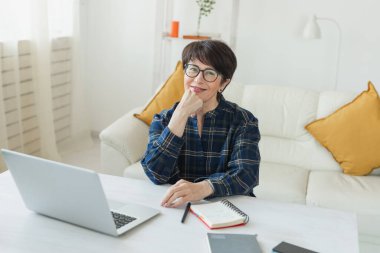 Pijama evinde dizüstü bilgisayarda çalışan iş kadını Coronavirus ya da Covid-19 konsepti sırasında ev idaresi yoluyla giyiniyor ve işlerini yönetiyor.