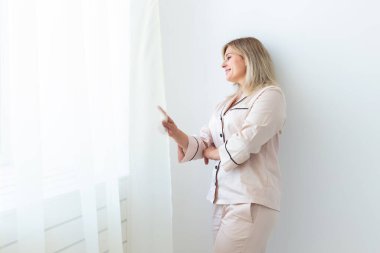 Pijamalı, güzel bir kadın model. Sabahın tadını çıkarıyor. Kanepede oturan hoş bir kadın. Keyfin yerinde..