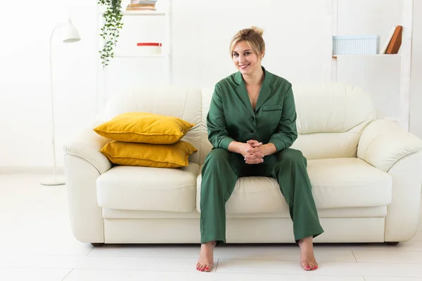 朝を楽しむパジャマ姿の可愛い女性モデル 快適な女性のソファに座っている 気分がいい — ストック写真