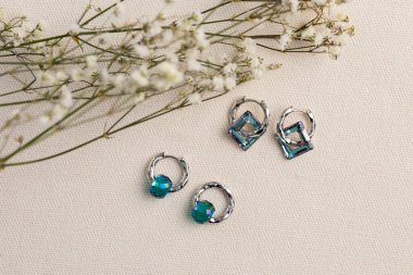 Mücevherli gümüş küpe seti. Mücevherler minimalist tarzda dizilmiş. El yapımı bijouterie