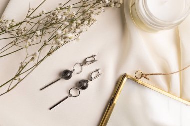 Mücevherli gümüş küpe seti. Mücevherler minimalist tarzda dizilmiş. El yapımı bijouterie