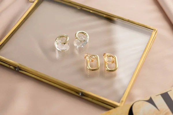 Elegant jewelry set of gold earrings with dried flower background. Jewelry set minimalist style. Handmade bijouterie