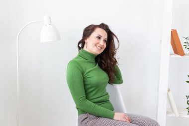 Oturma odasındaki sandalyede dinlenen mutlu kadın. Bekar bir kadın ve mutlu bir hayat.