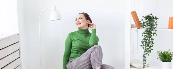 Happy emotions woman relaxing on chair at home in sitting room - single female and happy life