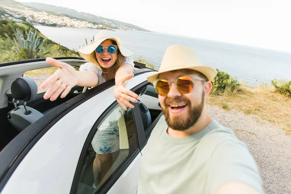 stock image Romantic couple making selfie on smartphone camera in rental cabrio car on ocean or sea beach, enjoying summer vacation together and taking picture cellular resting near sea on weekends