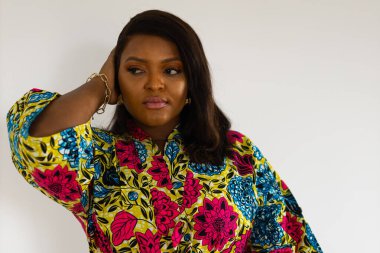 Gülümseyen Afro-Amerikan genç bayan, beyaz arka planda duran şık elbiseler giyer - kapsama ve çeşitlilik