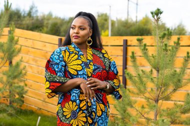 Güzel Afro-Amerikan kadın portresi. Köyde ya da banliyöde eğleniyor. Gülümseyen Afrikalı bir kızın açık hava portresi. Mutlu, neşeli bir kadın yaz mevsiminde gülüyor..