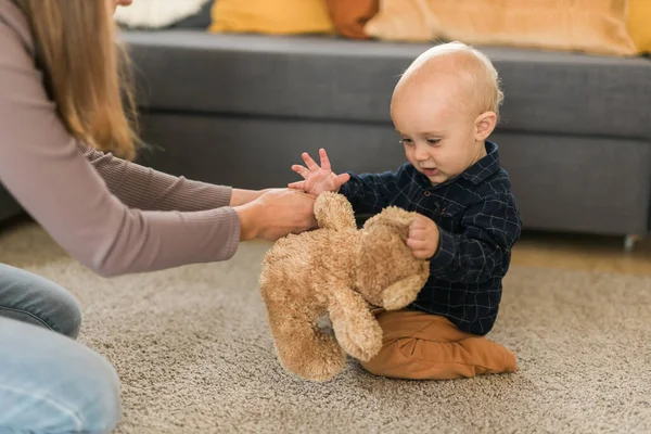 Child playing with teddy bear. Little boy hugging his favorite toy