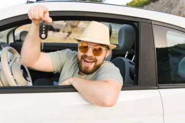 Yakışıklı mutlu adam yeni arabanın anahtarını gösteriyor - Kirala ve yeni bir araba al