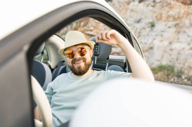 Yakışıklı mutlu adam yeni arabanın anahtarını gösteriyor - Kirala ve yeni bir araba al