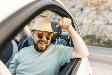 Yakışıklı mutlu adam yeni arabanın anahtarını gösteriyor - Kirala ve yeni bir araba al