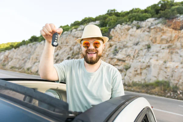 stock image Handsome happy man showing key of new car - Rental and buy new car