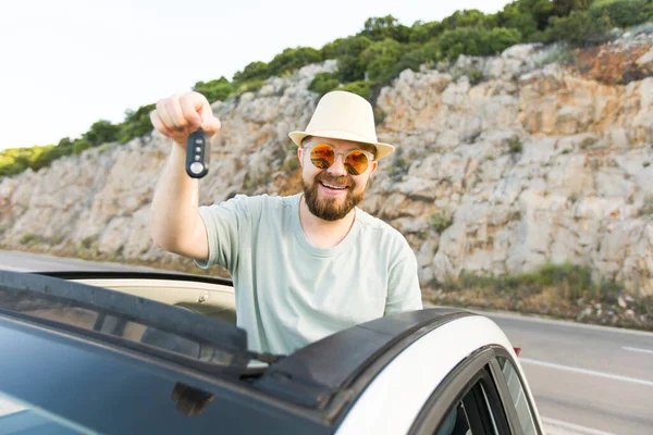 Yakışıklı mutlu adam yeni arabanın anahtarını gösteriyor - Kirala ve yeni bir araba al