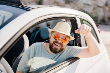 Yakışıklı mutlu adam yeni arabanın anahtarını gösteriyor - Kirala ve yeni bir araba al