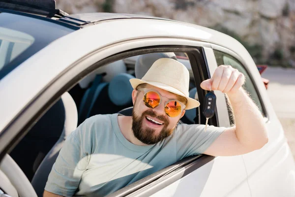 stock image Handsome happy man showing key of new car - Rental and buy new car