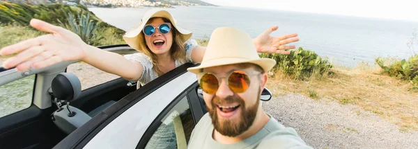 休暇中に路上でコンバーチブル車を運転する自撮りの肖像画を撮るのが大好き幸せな美しいカップル レンタカーとバケーションのコンセプト — ストック写真