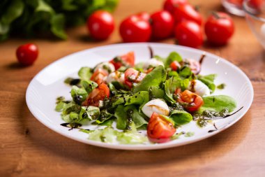 Plate of Healthy Classic Caprese Salad with Mozzarella Cheese, Tomatoes and Basil