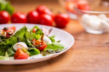 Plate of Healthy Classic Caprese Salad with Mozzarella Cheese, Tomatoes and Basil