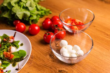 Bowl of small mozzarella balls in kitchen, top view.