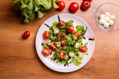 Plate of Healthy Classic Caprese Salad with Mozzarella Cheese, Tomatoes and Basil