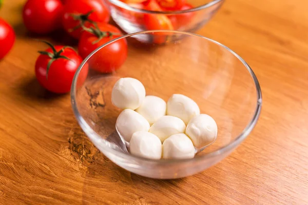 Bowl of small mozzarella balls in kitchen, top view.