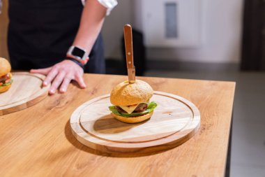 Ahşap masada sığır burger. Yağlı, sağlıksız yiyecekler.
