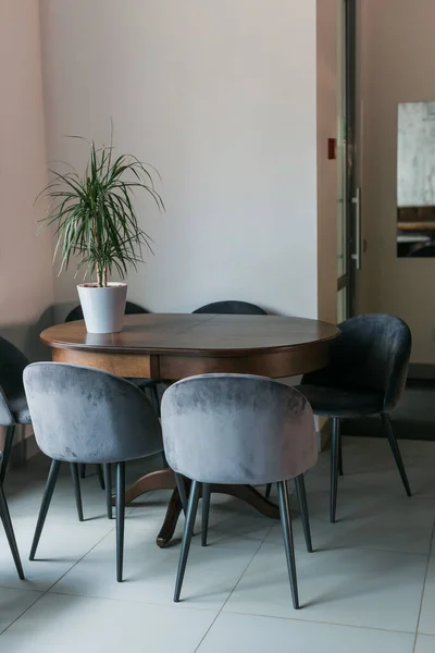 ポスターや窓のあるカフェのインテリアでミニマリストの木製のテーブルでグレーの椅子 — ストック写真